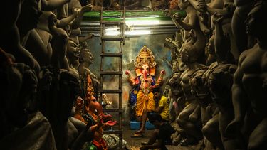 Los artesanos de Bombay, que venden ídolos de arcilla de la deidad hindú con cabeza de elefante Ganesha, esperan a los clientes en la víspera del festival Ganesh Chaturthi en el pueblo Kumartoli, en Calcuta, el 30 de agosto de 2022.