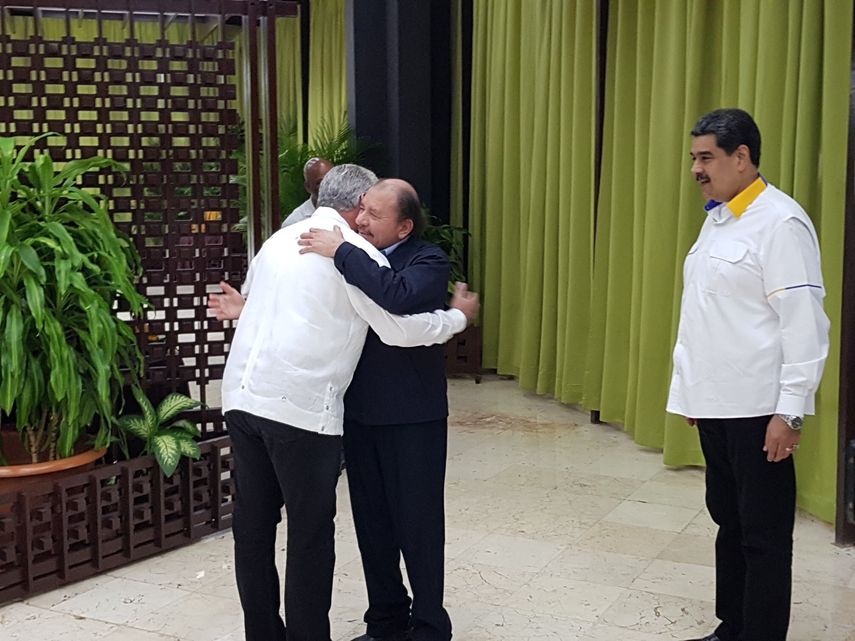 El dictador nicaragüense Daniel Ortega se abraza con el designado gobernante Miguel Díaz-Canel, a su llegada a La Habana, a la cumbre del ALBA. Observa el dictador venezolano Nicolás Maduro.