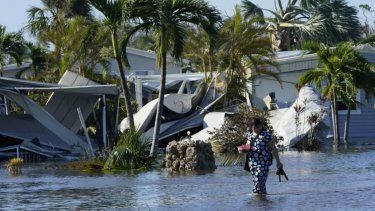 Holly Nugyn camina en su vecindario inundado y con casas destruidad por el paso del huracán Ian, en Fort Myers, en septiembre de 2022.