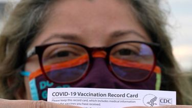 Alejandra, una dentista mexicana y que pidió no revelar su apellido, posa con su tarjeta de vacunación después de recibir la segunda dosis de la vacuna de Moderna contra el COVID-19.