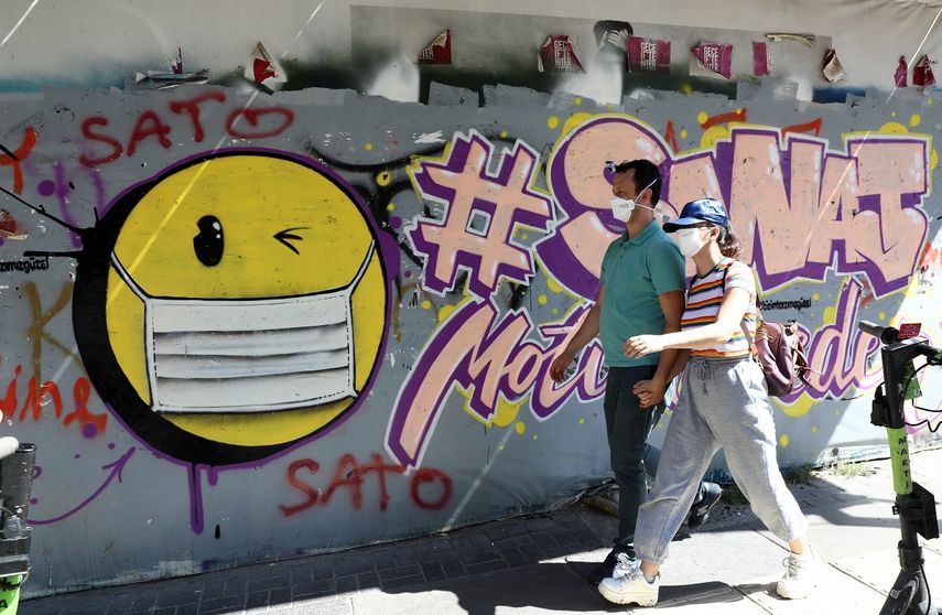 Dos personas caminan junto a una imagen que promueve el uso de la mascarilla en Ankara, Turqu&iacute;a, el 7 de septiembre de 2020.