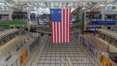 Una bandera estadounidense cuelga sobre la Terminal 1 prácticamente vacía en el Aeropuerto Internacional John F. Kennedy se Nueva York, el viernes 17 de febrero de 2023.&nbsp;
