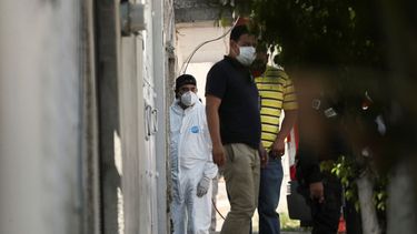 Un investigador forense permanece en la entrada de una vivienda donde la policía encontró restos óseos enterrados, en México