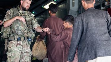 Una fotografía publicada por el Ministerio de Defensa británico el 24 de agosto de 2021 y tomada el 22 de agosto de 2021 muestra a un miembro de las Fuerzas Armadas del Reino Unido golpeando a un evacuado durante su despliegue para apoyar la evacuación de ciudadanos británicos y personal autorizado en Kabul. aeropuerto en Afganistán.