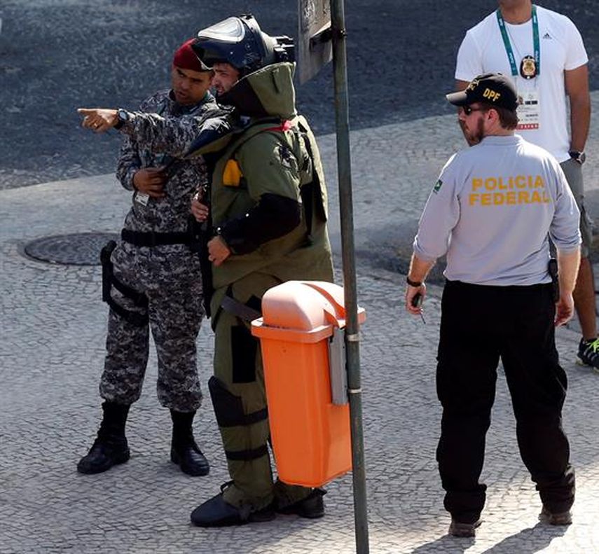 Integrante del escuadrón de antibombas de la policía federal de Brasil inspecciona un área luego de una explosión controlada de un artefacto. (EFE) 