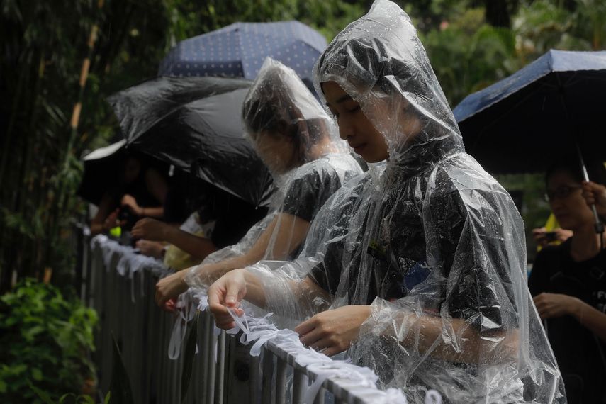 Manifestantes prodemocracia atan lazos blancos, que simbolizan la pureza de las intenciones de los j&oacute;venes participantes, durante una marcha organizada por profesores, en Hong Kong, el 17 de agosto de 2019.&nbsp;
