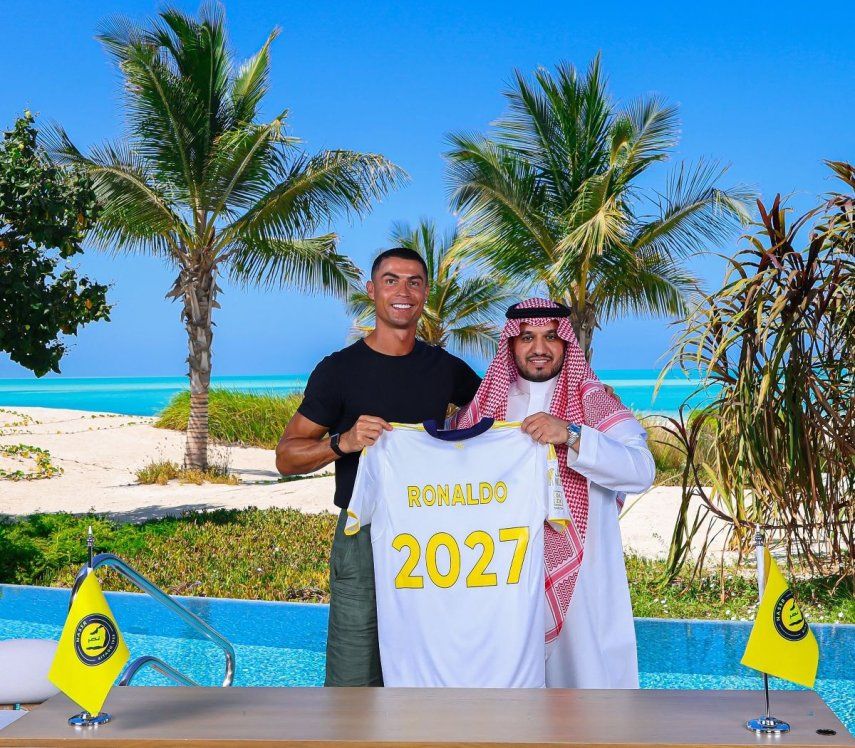 Esta foto, publicada por el Club de Fútbol Al-Nassr el 26 de junio de 2025, muestra al delantero portugués Cristiano Ronaldo (izq.) posando para una fotografía con el presidente del club, Abdullah Al-Majid, tras firmar un nuevo contrato con el club saudí en un lugar no revelado. Ronaldo firmó una extensión de contrato por dos años con el Al Nassr de Arabia Saudí, anunció el club el 26 de junio, tras meses de especulaciones sobre el equipo al que ficharía para la próxima temporada. (Foto de Al Nassr Football Club / AFP) / USO EDITORIAL RESTRINGIDO - CRÉDITO OBLIGATORIO AFP PHOTO / HO /AL NASSR FOOTBALL CLUB - SIN MARKETING NI CAMPAÑAS PUBLICITARIAS - DISTRIBUIDO COMO SERVICIO A CLIENTES