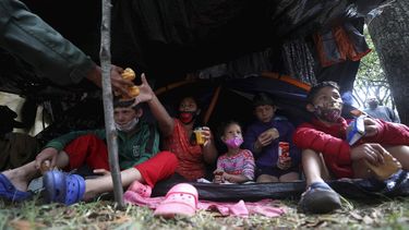 Una familia de migrantes venezolanos desayuna en un campamento cerca de la terminal principal de autobuses en Bogotá, Colombia.