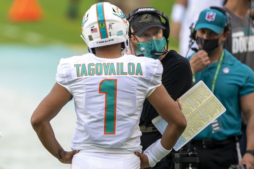 El mariscal de campo de los Dolphins, Tua Tagovailoa (1), habla con el entrenador de mariscales de campo de Miami, Robby Brown, durante un juego de fútbol americano, el domingo 1 de noviembre de 2020