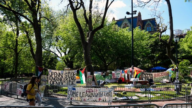 Estudiantes caminan frente al Campamento de Solidaridad con Gaza en la Universidad de Pensilvania.