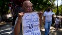 Carlos Blanco, de 84 años, supervisor de ambulancias retirado, sostiene un cartel que anuncia el pago mensual de su pensión de $1.50 dólares durante una protesta en que demandaban un incremento en los pagos en medio de una inflación récord en Caracas, Venezuela. Venezuela tiene poco más de cinco millones de pensionados, según cifras oficiales.