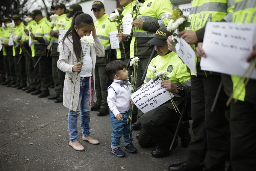 Niños reciben flores de parte de integrantes de la Policía de&nbsp;Colombia&nbsp;durante un homenaje a los cadetes muertos por la explosión del carro bomba contra la Escuela de la Policía General Santander.