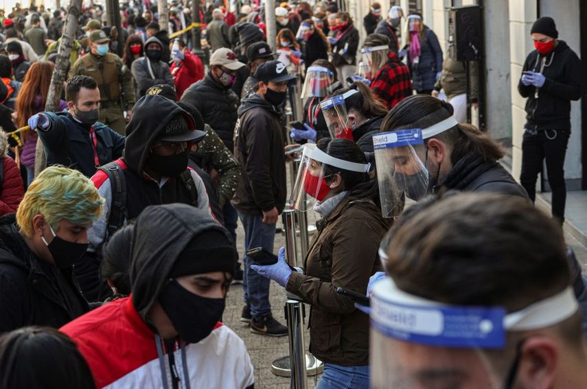 Empleados del gobierno usando mascarillas y caretas para protegerse del nuevo coronavirus ayudan a que la gente procese su retiro de un porcentaje de sus fondos de ahorro para el retiro en Santiago de Chile el jueves 30 de julio de 2020.&nbsp;