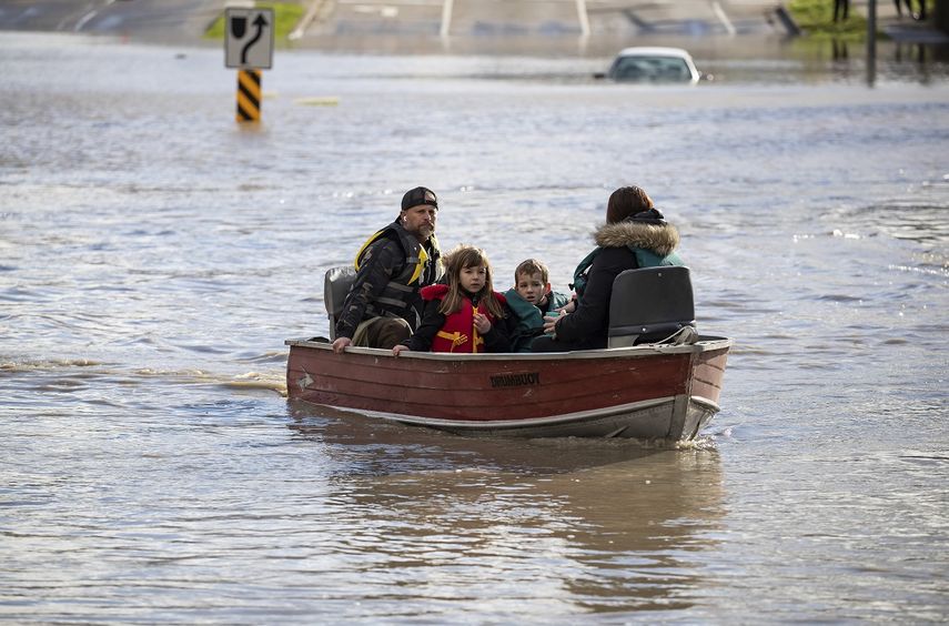 Una mujer y dos niños que estaban varados debido a las inundaciones son rescatados por un voluntario con un bote en Abbotsford, Columbia Británica, el 16 de noviembre de 2021. Las autoridades describieron como devastador el daño causado por varios días de lluvias, que provocaron inundaciones y aludes de lodo.&nbsp;&nbsp;