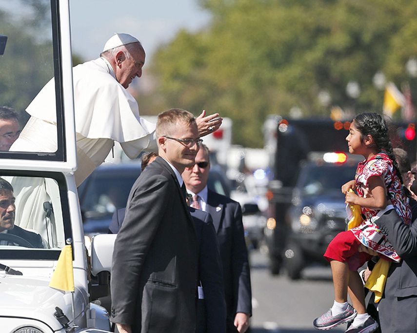 El papa Francisco saluda a una niña desde el papamovil por las calles de Washington. (EFE)