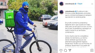 El venezolano Rubén Limador posa en su bicicleta en la que trabaja en un servicio de Delivery