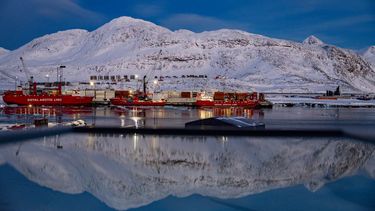 El puerto y la montaña detrás se reflejan en una ventana en Nuuk, Groenlandia.