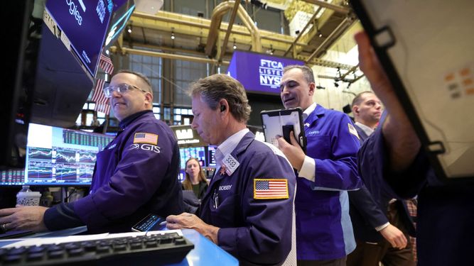 Agentes de la Bolsa de Nueva York trabajan en el piso de remate antes del cierre de sesión.