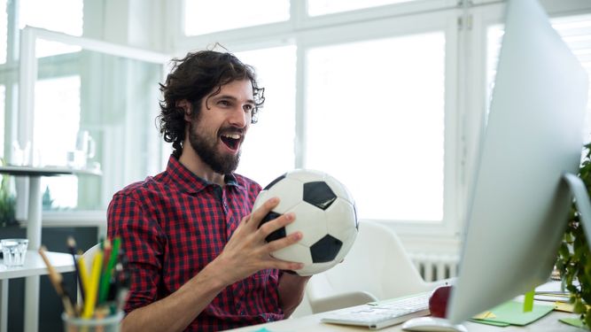 Hombre animando mientras ve un partido de fútbol