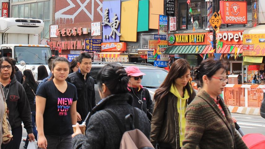 Un grupo de personas camina por la avenida Roosevelt, en el distrito de Queens, Nueva York.