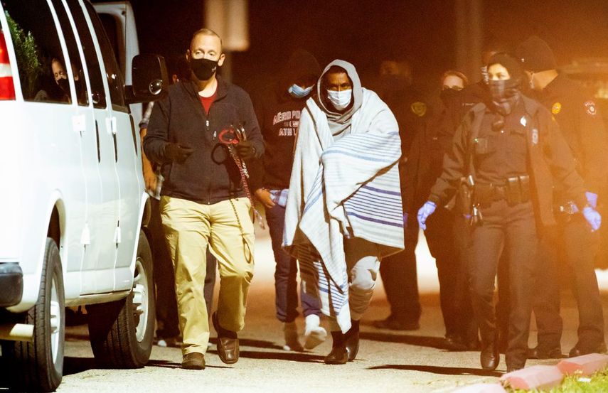 Varias personas esposadas en pares son subidas a camionetas el jueves 4 de diciembre de 2020 durante una investigación de la policía sobre un posible caso de contrabando humano, en Houston.&nbsp;