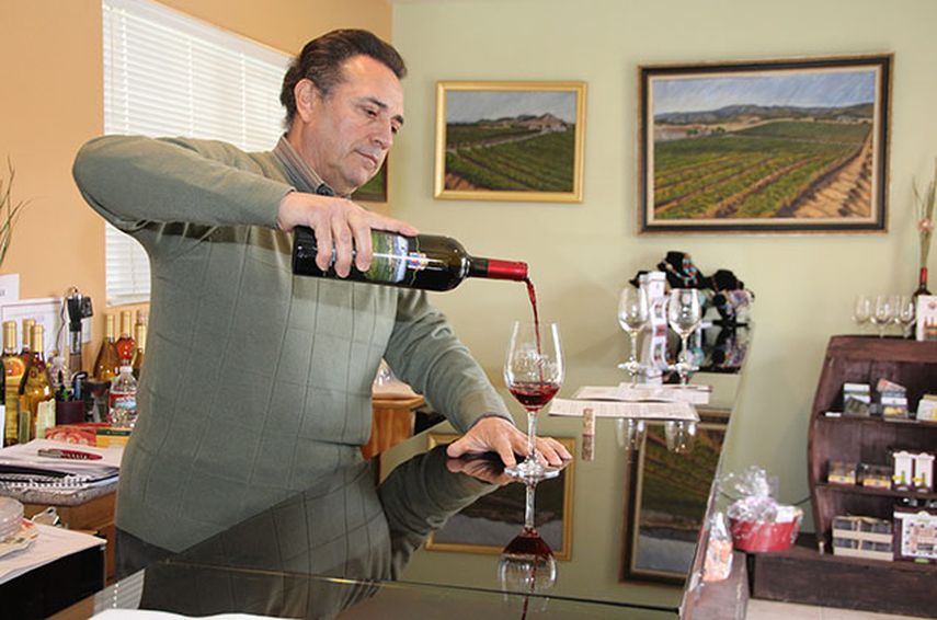 Roberto Reyes, propietario de la bodega Reyes Winery llena un vaso de vino de su producción, en la zona rural de Agua Dulce, California. EFE/Iván mejía