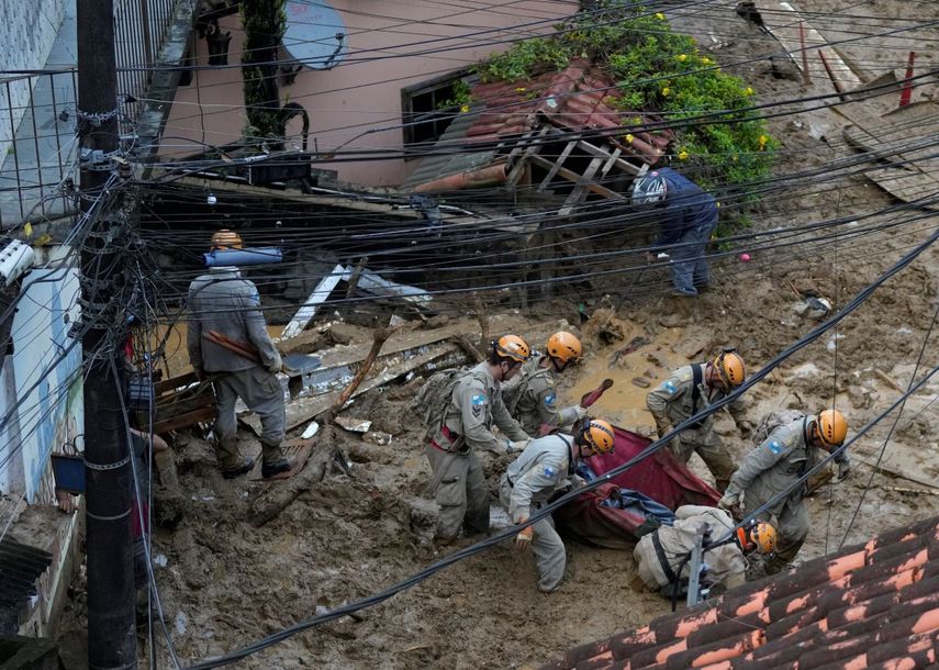 Rescatistas trasladan el cadáver de una víctima de un deslave, en Petrópolis, Brasil, el 16 de febrero de 2022. (AP Foto/Silvia Izquierdo)