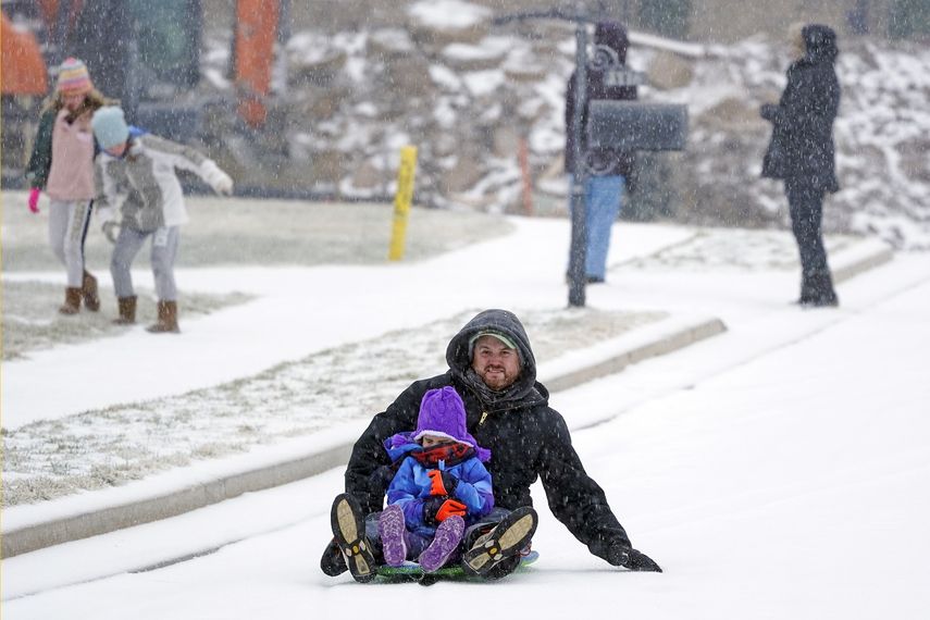 Andy German y Lyla, de 6 años, se deslizan por una calle nevada el lunes 15 de febrero de 2021, en Nolensville, Tennessee.&nbsp;