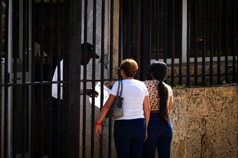 Dos personas esperan su turno en el exterior de la embajada de EEUU el día después de la reapertura de los servicios consulares, en La Habana, Cuba.