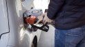 Una persona rellena de combustible su auto. Una persona rellena de combustible su auto.