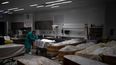 Un empleado de la casa funeraria Sancho de Ávila de Barcelona prepara el cadáver de una persona cuya muerte no estuvo vinculada con el coronavirus el 14 de abril del 2020. Las funerarias se han visto desbordadas por las muertes causadas por el virus y los cadáveres de personas fallecidas por el COVID-19 no pueden ser retocados. Como llegan son depositados en los féretros, sin ser sacados de sus bolsas.