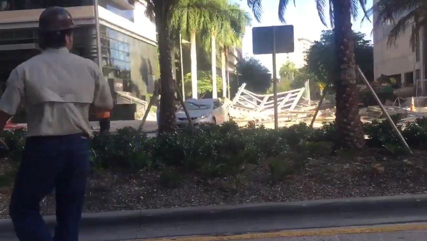 Vista de un auto dañado por la caída de un andamio de un edificio en construcción en Brickell, Miami.