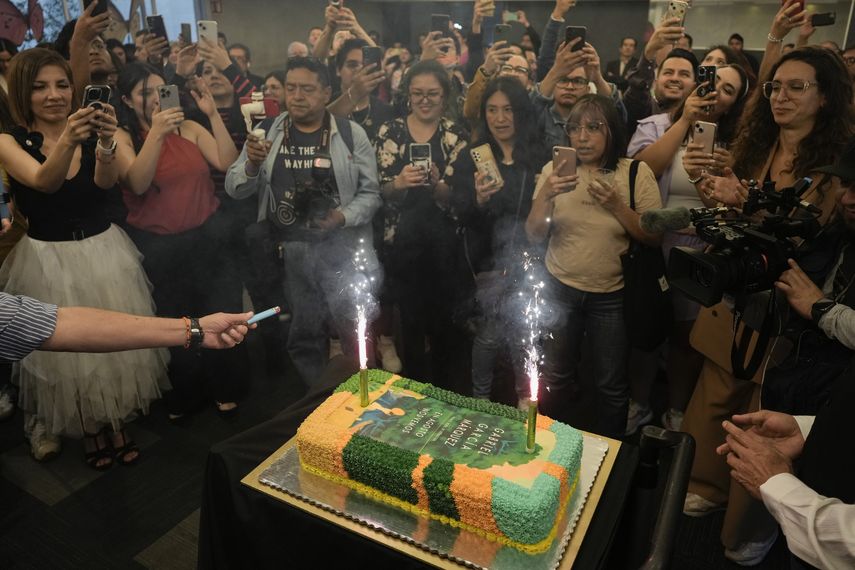 Personas reunidas alrededor de un pastel decorado con la portada de la novela En agosto nos vemos para celebrar el cumpleaños del autor colombiano Gabriel García Márquez y el lanzamiento de su novela póstuma en una librería en la Ciudad de México el miércoles 6 de marzo de 2024.