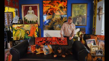 El pintor, junto a obras y su mascota Sajar.