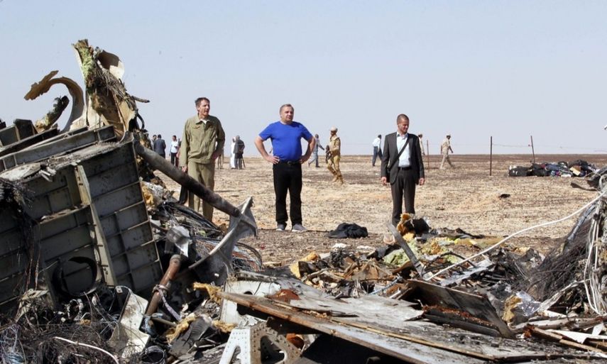Varias personas observan los restos del avión Airbus 320 ruso en el desierto El Sinaí. (EFE)