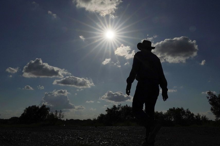 Jessie Fuentes, que trabaja con canoas y kayaks, camina por el Río Grande bajo un sol cálido el jueves 6 de julio de 2023. Mientras el planeta bate récords de calor, debilitando y enfermando a la gente, merece la pena recordar que las olas de calor han inspirado esfuerzos por prevenir sus efectos. 