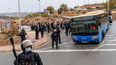 La policía española escolta a migrantes en autobuses tras haberlos reunido mientras dormían a la intemperie cerca de los almacenes de El Tarajal, en las afueras de Ceuta —enclave español en el norte de África—, el 18 de octubre de 2026.