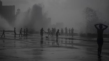 La gente juega en las olas que rompen en el Malecón, después del huracán Ian en La Habana, Cuba, el miércoles 28 de septiembre de 2022.&nbsp;
