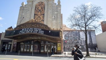 Una mujer con una m&aacute;scara para protegerse del coronavirus camina frente al cine Kings Theatre, el 11 de abril de 2020, en el barrio de Flatbush en el distrito de Brooklyn de Nueva York.&nbsp;