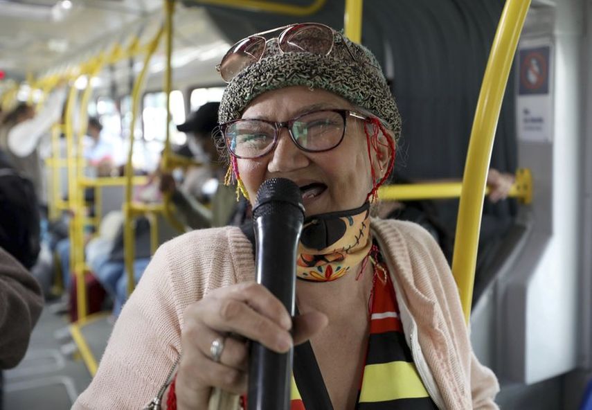 Marlene Alfonso, una abuela venezolana de 69 años que se hace llamar Cindy sin dientes, canta sobre la vida de los migrantes de su país con la esperanza de recibir propinas de los viajeros en el Transmilenio, el sistema de autobuses públicos atestado y asotado por el crimen en Bogotá, el martes 3 de noviembre de 2020.