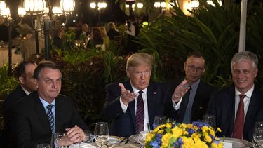 El presidente Donald Trump, al centro, acompañado por su homólogo brasileño, Jair Bolsonaro (izq), y por el asesor de Seguridad Nacional Robert OBrien, dufrante una cena en Mar-a-Lago, Palm Beach, Florida, el sábado 7 de marzo de 2020.