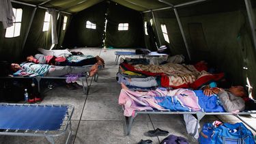 Un grupo de hombres duerme en un cuartel militar en Ecuador habilitado para ofrecer apoyo a los venezolanos que huyen de la crisis de su país. 
