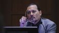 El actor Johnny Depp demuestra cómo afirma que se protegió de un presunto ataque de su ex esposa Amber Heard mientras testifica durante su juicio por difamación contra Heard, en el juzgado de circuito del condado de Fairfax en Fairfax, Virginia, el 20 de abril de 2022.&nbsp;