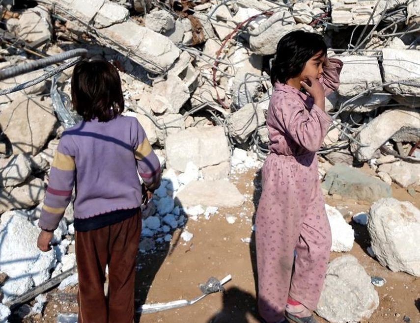 Niños junto a los escombros de un edificio residencial derrumbado por una bomba tirada por un avión en el sur de Jaramana city, Damascus, Syria (EFE)
