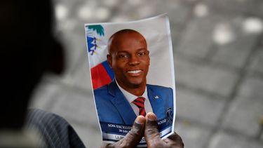 Una persona sostiene una fotografía de difunto presidente Jovenel Moïse durante una ceremonia fúnebre en el Museo y Cementerio Nacional, el martes 20 de julio de 2021, en Puerto Príncipe, Haití. 