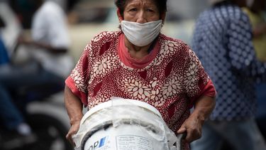 Una mujer, con mascarilla para protegerse del coronavirus, empuja un carrito con recipientes llenos de agua, en Caracas, Venezuela, el 20 de junio de 2020. Se estima que el 86% de los venezolanos reportó problemas con el suministro de agua, incluyendo un 11% que no tiene, según una encuesta realizada por la ONG Observatorio Venezolano de Servicios Públicos entre 4.500 residentes en abril