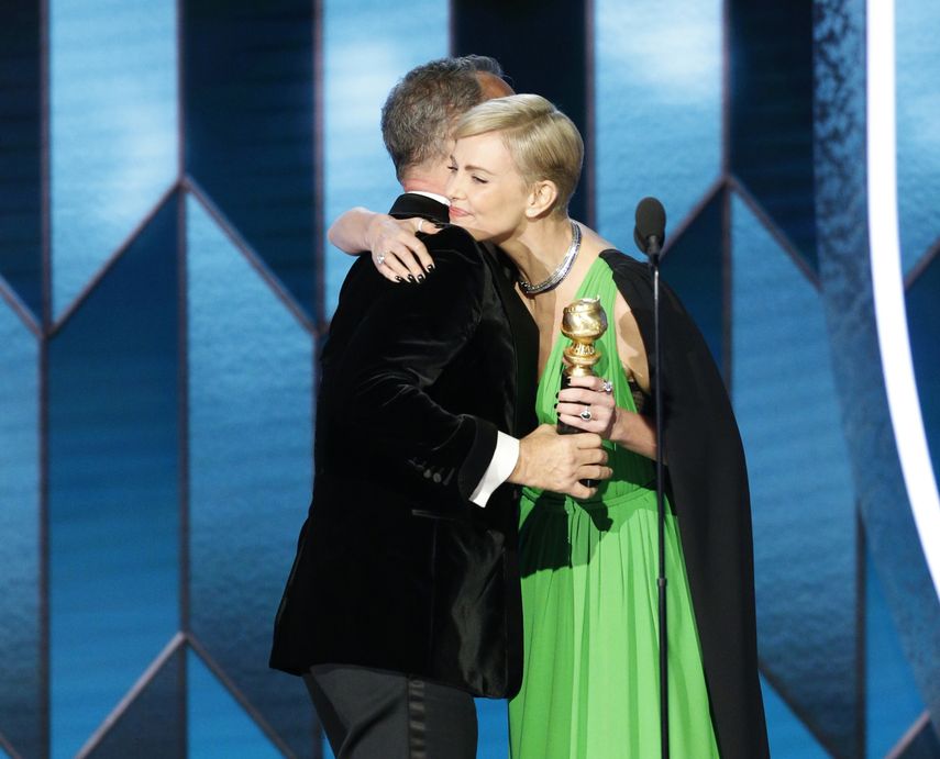 En esta imagen difundida por NBC, Tom Hanks recibe el Premio Cecil B. DeMille a la Trayectoria de manos de Charlize Theron durante la ceremonia de los Globos de Oro.&nbsp;
