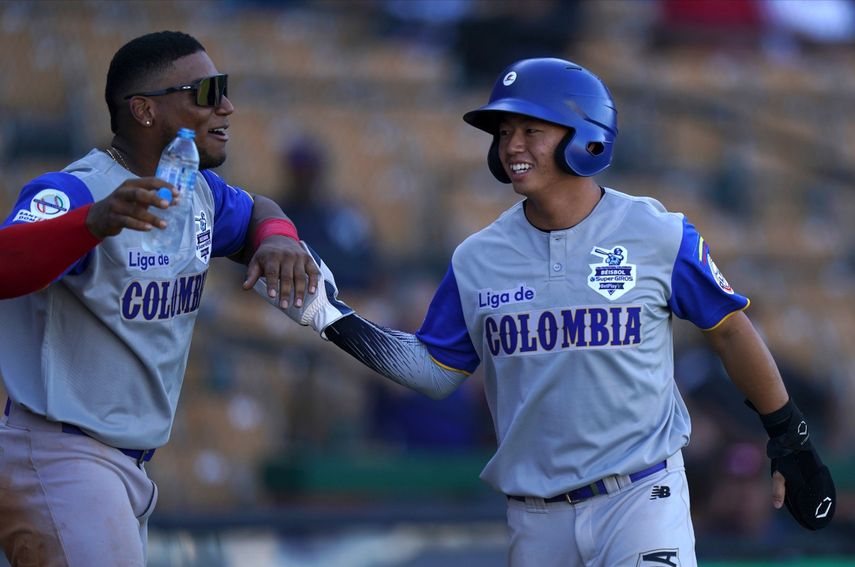 Tsung Che Cheng, de Colombia, es felicitado tras anotar ante Venezuela en un encuentro de la Serie del Caribe, el viernes 28 de enero de 2022, en Santo Domingo&nbsp;
