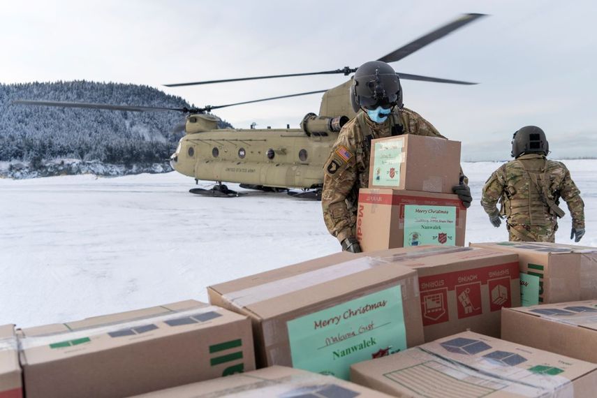 En esta fotografía facilitada por la Guardia Nacional de Alaska, soldados descargan regalos de un helicóptero CH-47 Chinook en Nanwalek, Alaska, durante la llamada Operación Santa Claus, el viernes 11 de diciembre de 2020.&nbsp;