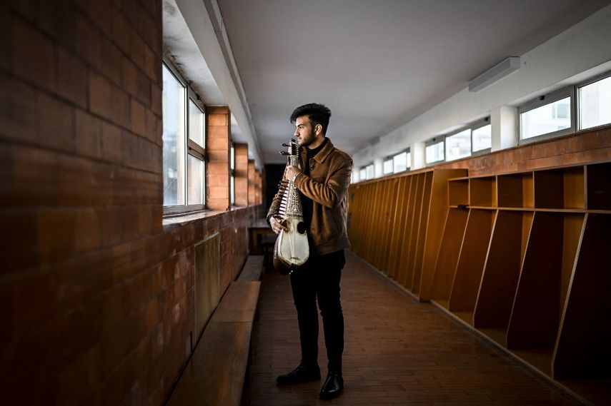 Ramiz, de 19 años, estudiante de música del Instituto Nacional de Música de Afganistán, posa sosteniendo un instrumento afgano llamado rubab, en el Conservatorio de Música de Braga, el 5 de marzo de 2021. Un año y medio después de huir Afganistán, los 58 jóvenes músicos del Instituto Nacional de Música de Afganistán comienzan una nueva vida refugiados en Braga, en el norte de Portugal.